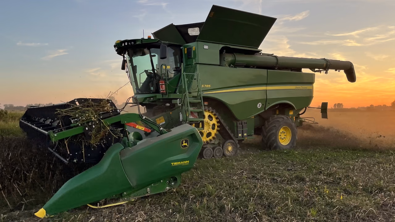 Mähdrescher mit Raupenlaufwerk erntet im Abendrot